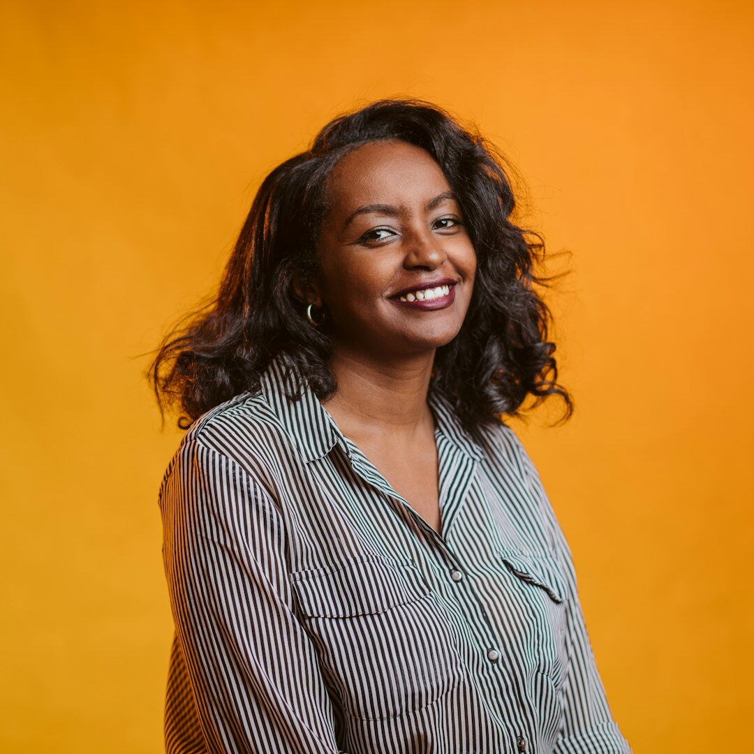 Studio portrait of a smiling woman with curly hair